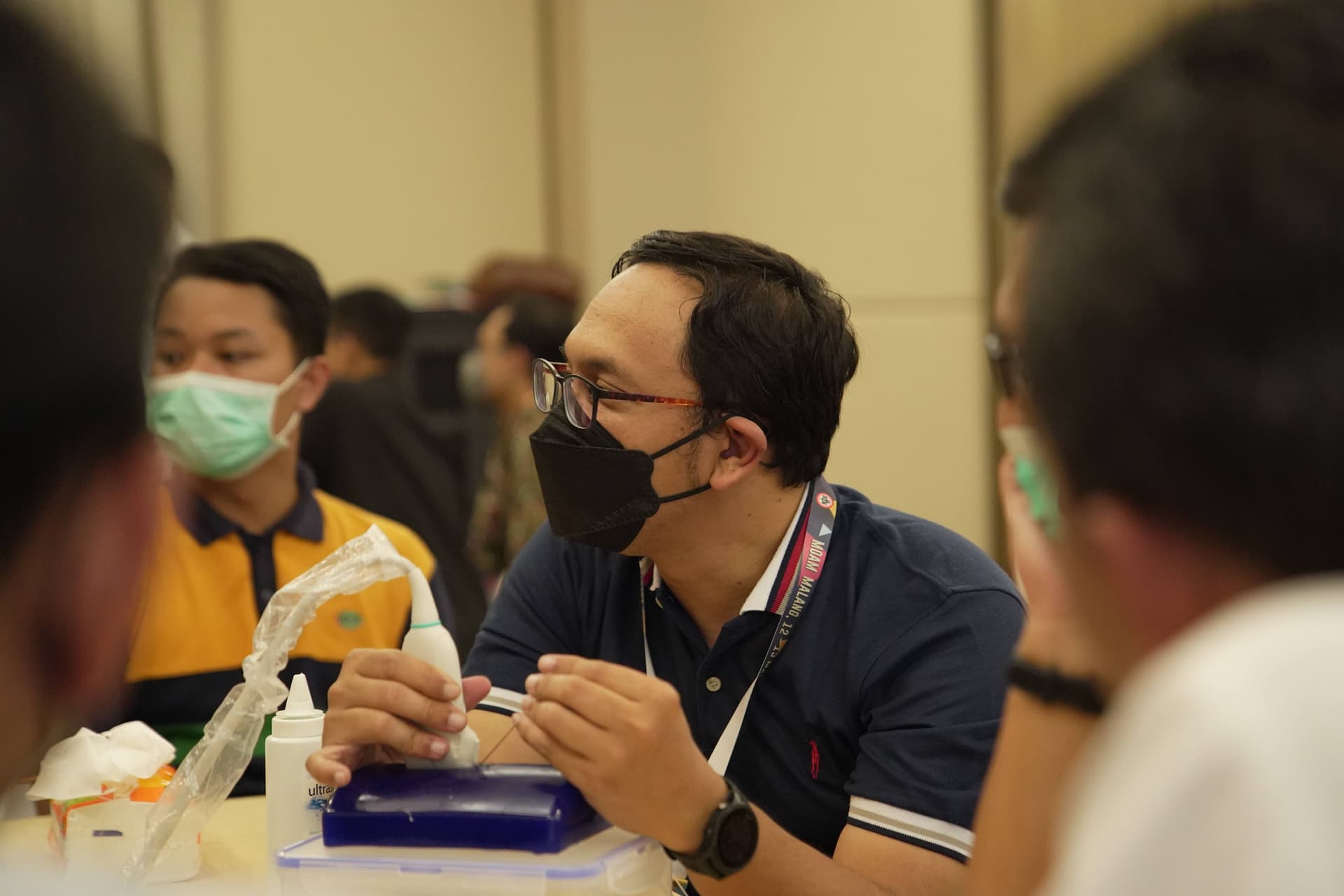 Medical workshop participants practicing with catheter equipment