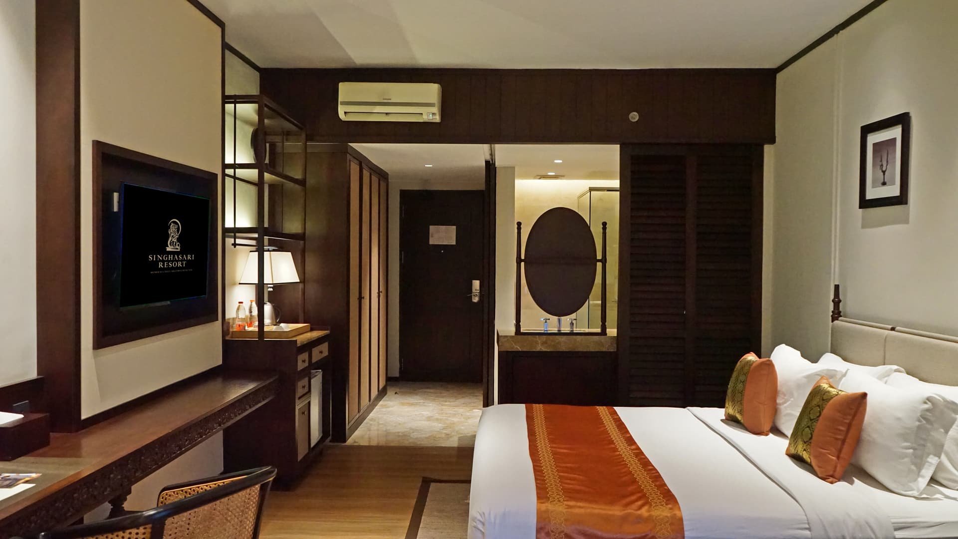 Deluxe Room - King bed with orange accents and bathroom view